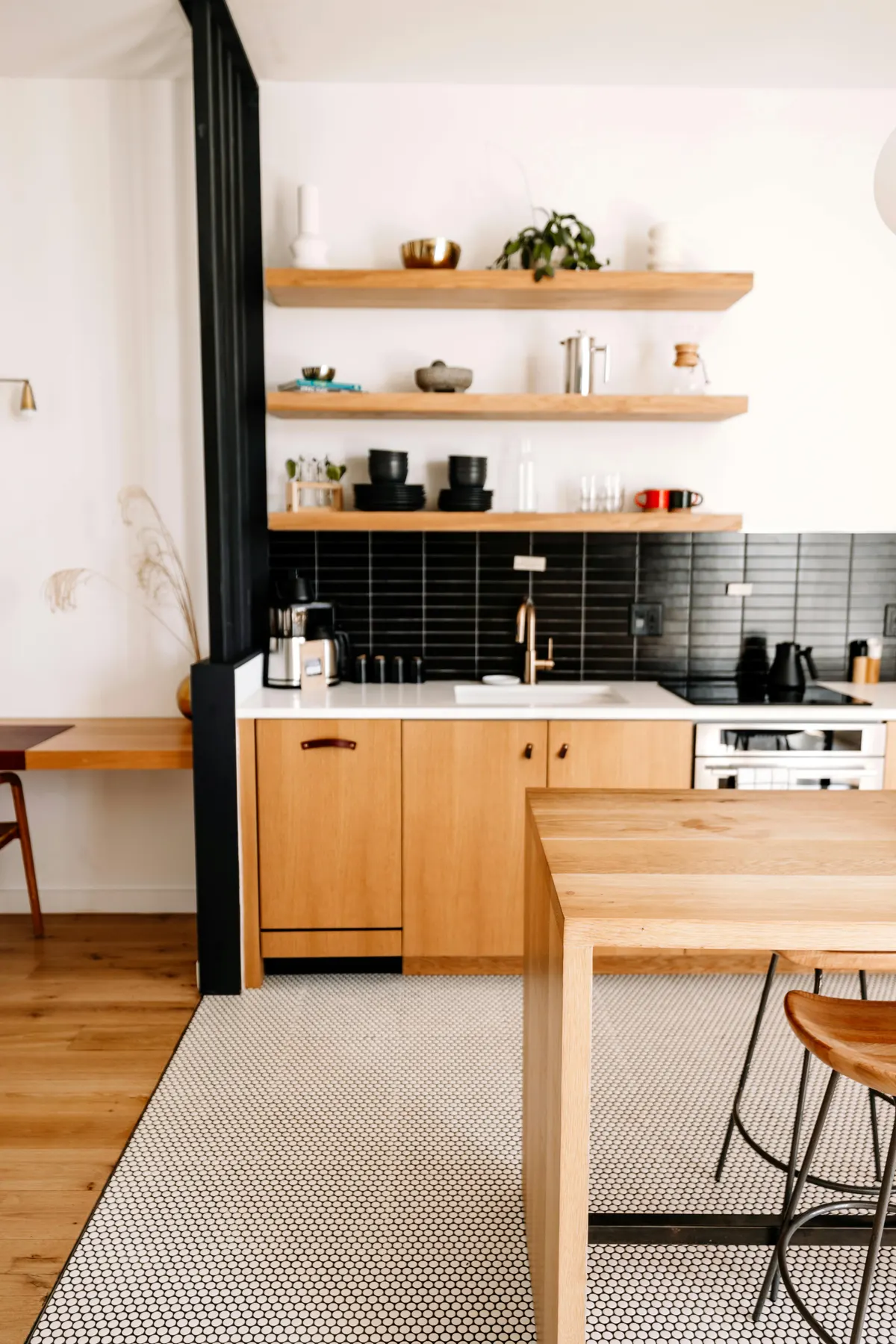 Kitchen with black tile backsplash and open shelving in Inglewood Calgary